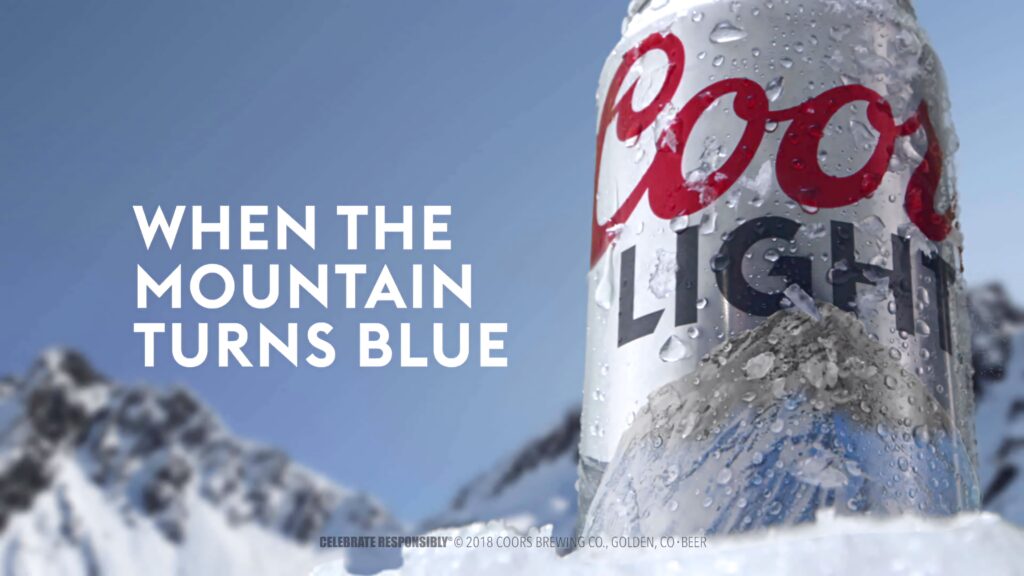 Chilled Coors Light can with ice condensation and snowy mountains highlighting refreshment Wallpaper