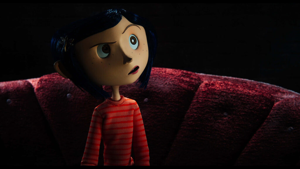 Coraline with blue hair and striped shirt against red velvet backdrop in stop-motion style wallpaper