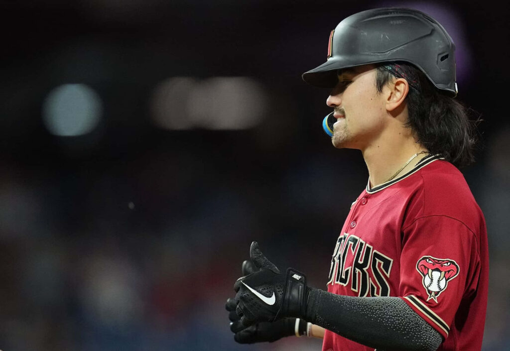 Corbin Carroll in Arizona Diamondbacks uniform mid-game intense focus vivid maroon jersey baseball wallpaper
