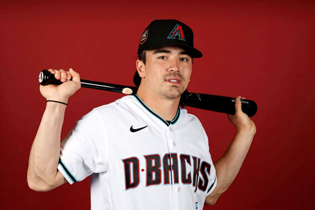Corbin Carroll Arizona Diamondbacks baseball player with bat on shoulders red background wallpaper