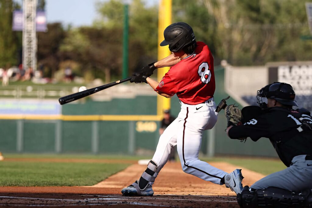 Corbin Carroll swinging in red jersey number 8 on sunlit baseball field vibrant athletic action wallpaper