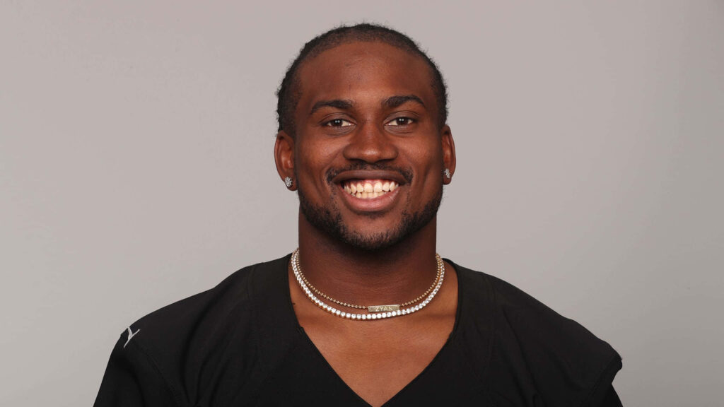 Cordarrelle Patterson smiling in black athletic uniform vibrant sports wallpaper background gray