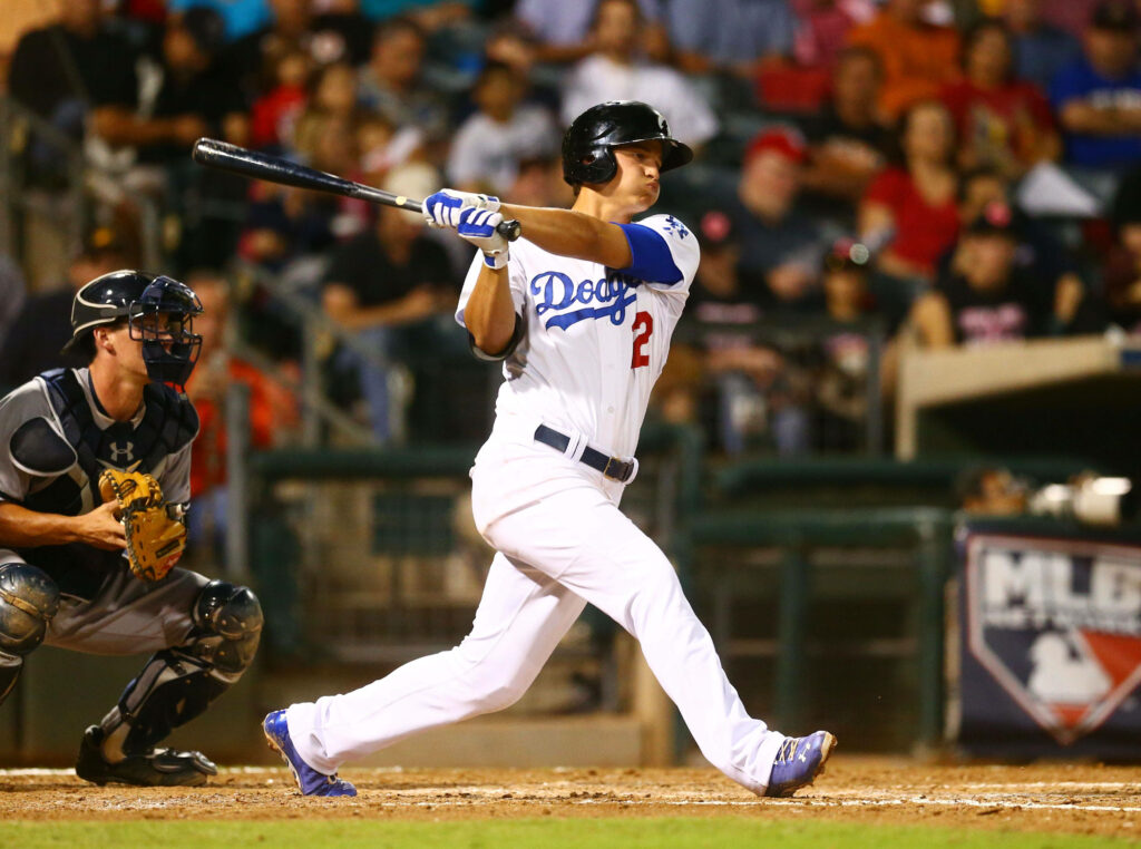 Corey Seager swinging bat in Dodgers uniform focused during dynamic baseball game action Wallpaper