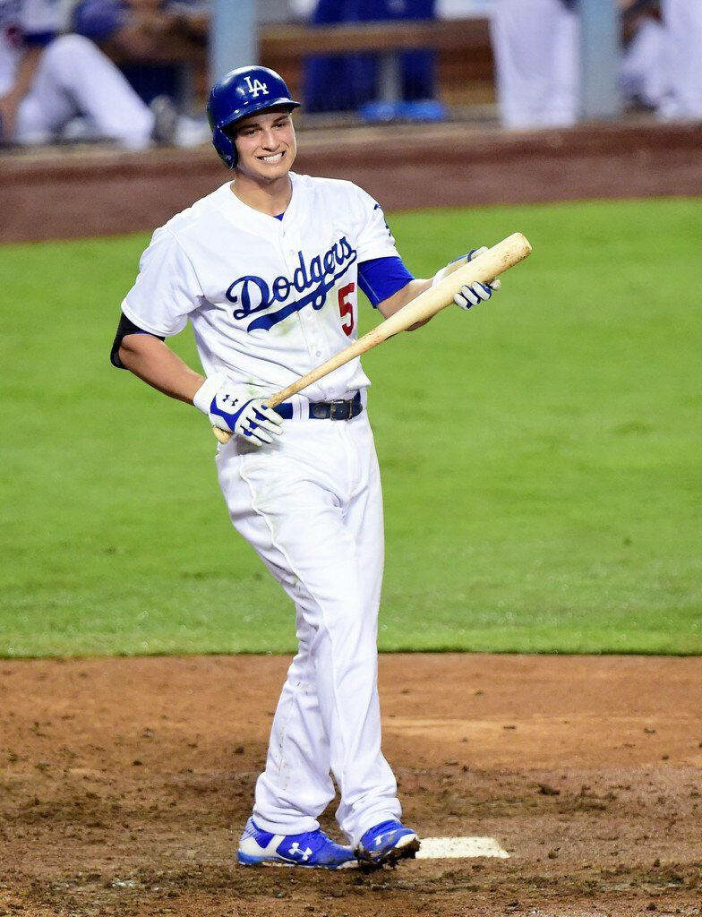 Corey Seager walking mid game with bat in Los Angeles Dodgers uniform on vibrant stadium field Wallpaper
