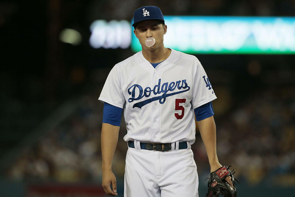 Corey Seager in Dodgers uniform blowing bubblegum bubble focused in stadium baseball game background Wallpaper