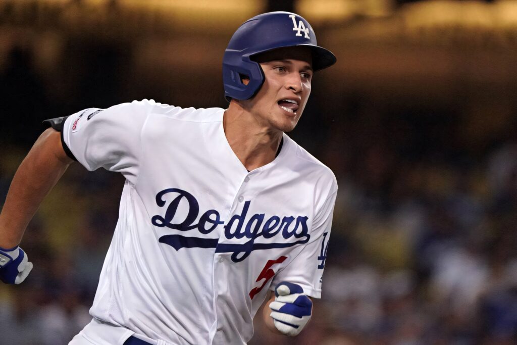 Corey Seager running in Dodgers white and blue uniform during intense baseball game action wallpaper
