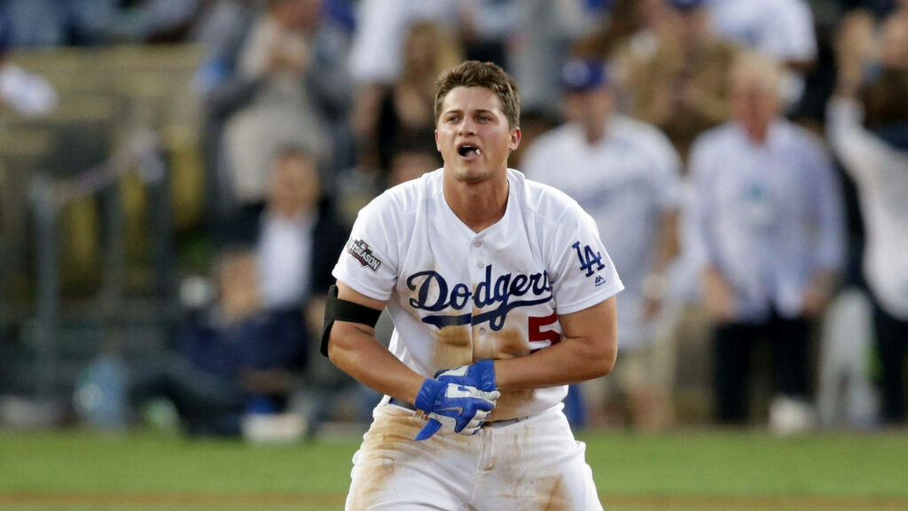 Corey Seager crouching on baseball field in dirty white Dodgers uniform showing intense play Wallpaper
