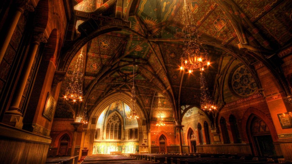 Interior view of Cornell University Sage Chapel with Gothic architecture and glowing chandeliers Wallpaper