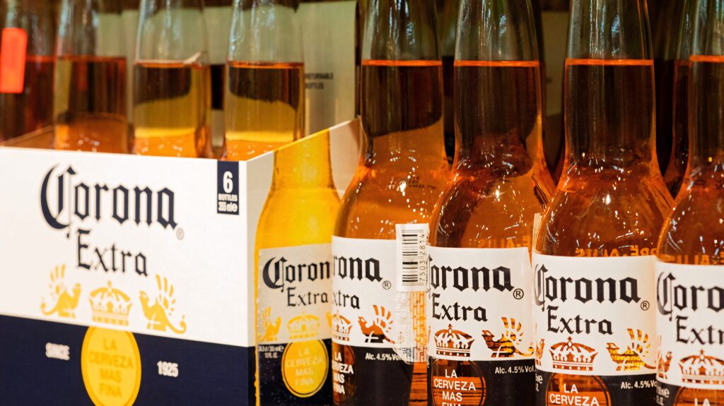 Corona Extra beer bottles lined up showing golden amber color and iconic branding wallpaper