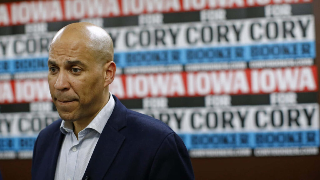 Cory Booker at Iowa campaign event with red blue black and white signage showing his name Wallpaper