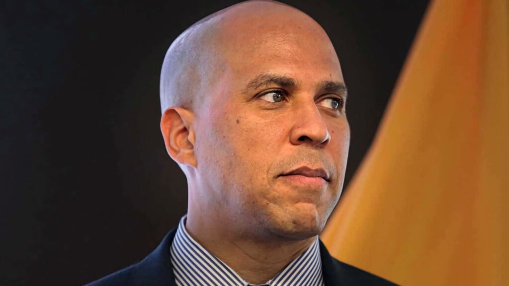 Portrait of U.S. Senator Cory Booker with focused expression warm tones modern realistic style Wallpaper