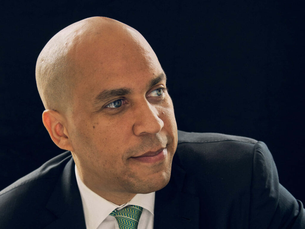 Close-up portrait of Cory Booker in suit and patterned tie with thoughtful expression wallpaper
