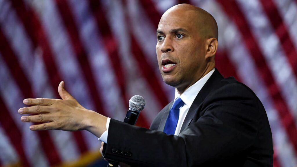 Cory Booker Senator speaking passionately red white and blue background high resolution wallpaper