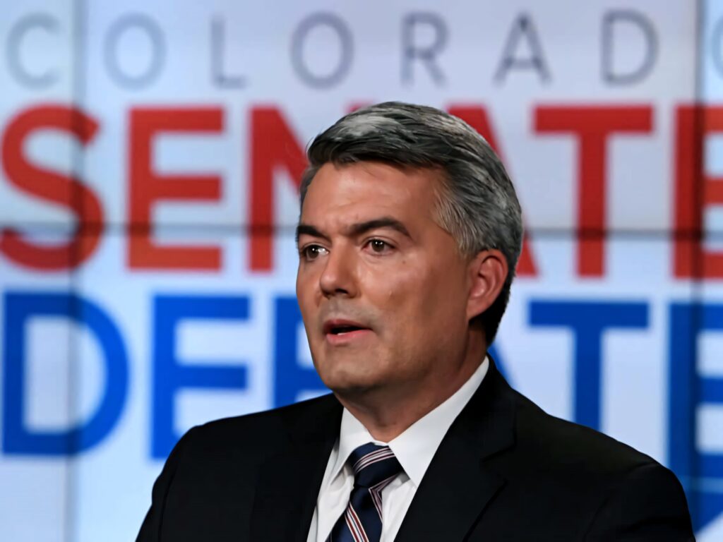 Cory Gardner at Colorado Senate debate with vibrant bold text political wallpaper background