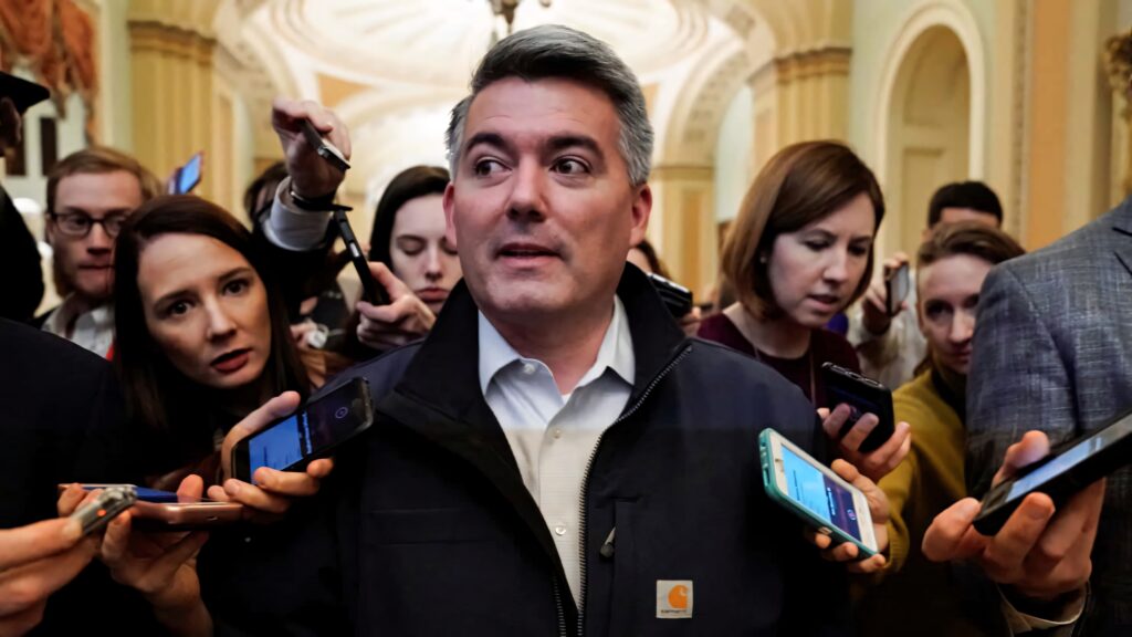 Cory Gardner speaking at a busy press conference with journalists and microphones under arches Wallpaper