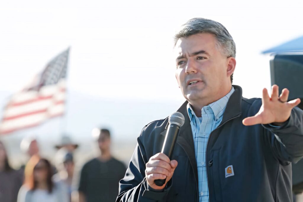 Cory Gardner speaking outdoors with microphone American flag crowd leadership community event Wallpaper