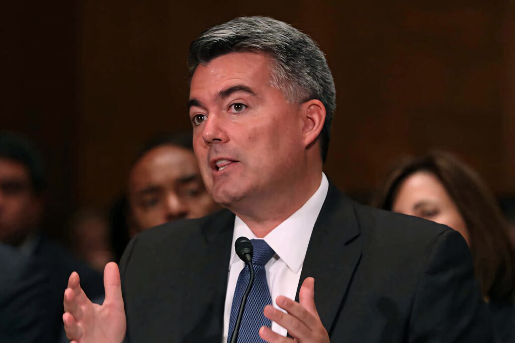 Cory Gardner speaking passionately in dark suit tie blurred professional political setting wallpaper