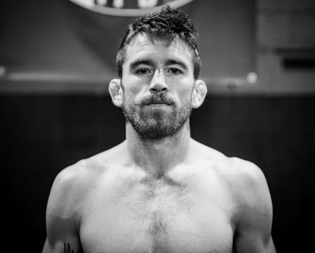 Grayscale portrait of UFC fighter Cory Sandhagen with intense focused expression and athletic build Wallpaper