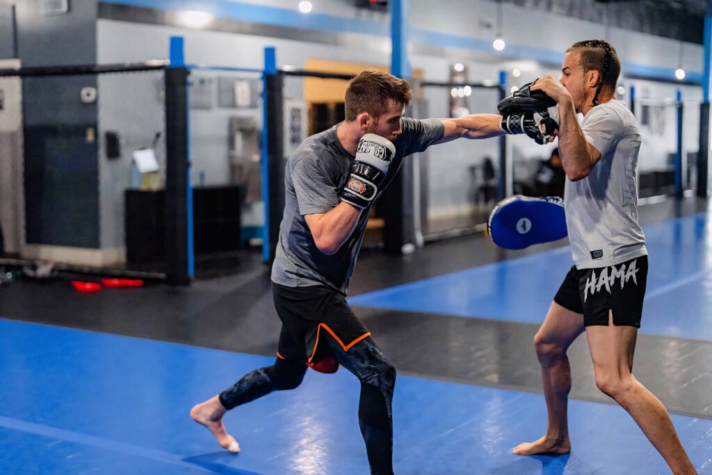 Cory Sandhagen sparring with trainer in MMA gym blue mats showing focus technique and discipline Wallpaper