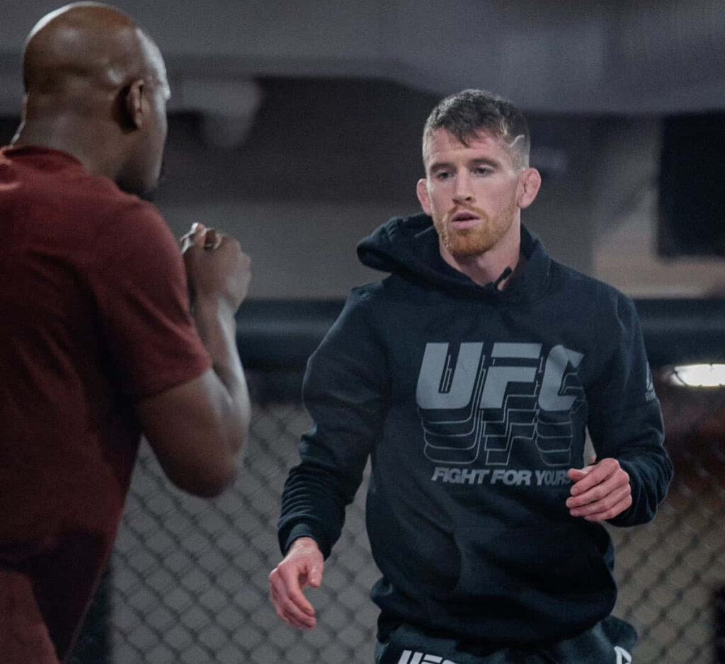 Cory Sandhagen training inside UFC gym focused in hoodie intense sparring session octagon backdrop Wallpaper