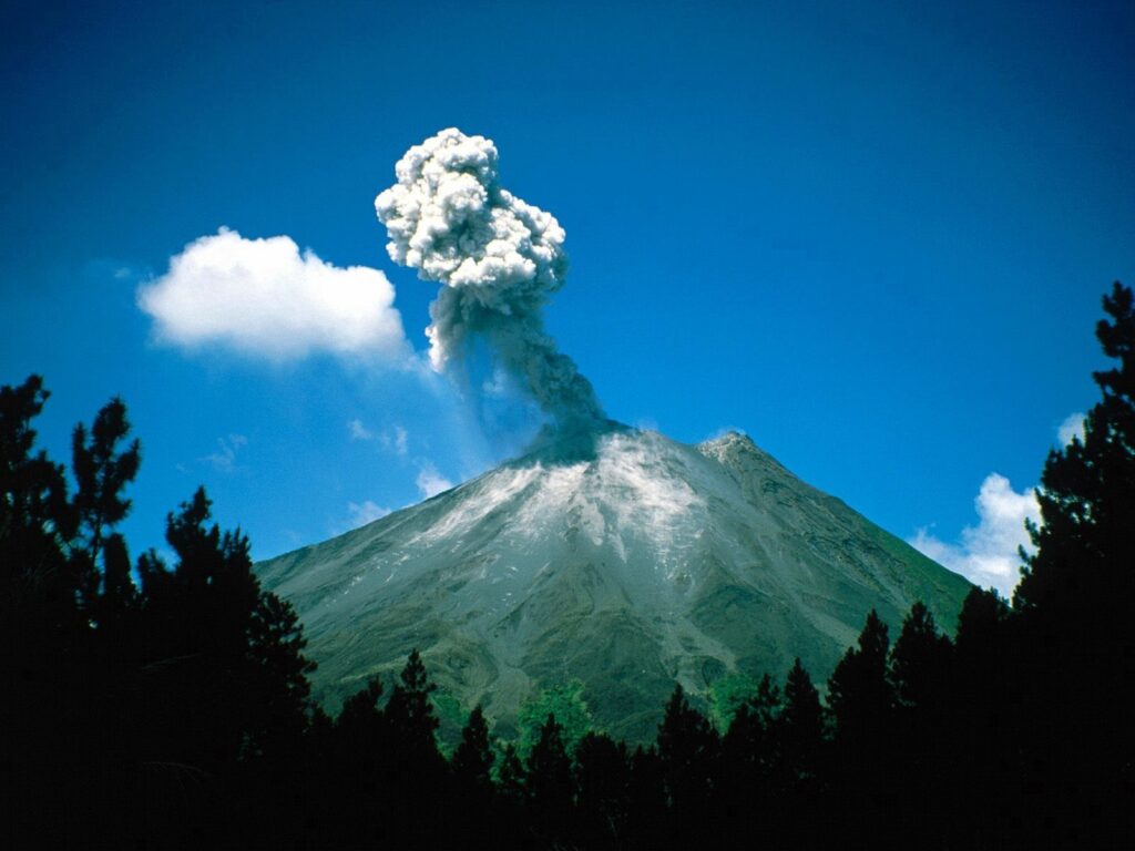 Costa Rica volcano erupting with thick smoke and lush trees under a vibrant blue sky wallpaper