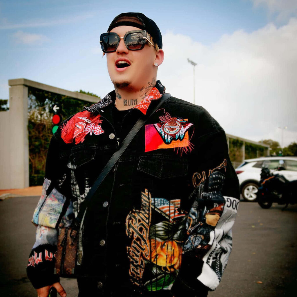 Costa Titch outdoors in vibrant street style wearing graphic black jacket and oversized sunglasses Wallpaper