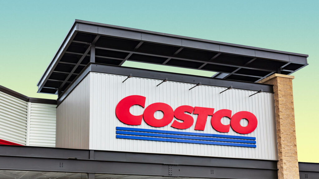 Close-up of bold red Costco sign on white building with modern lines and bright gradient sky Wallpaper