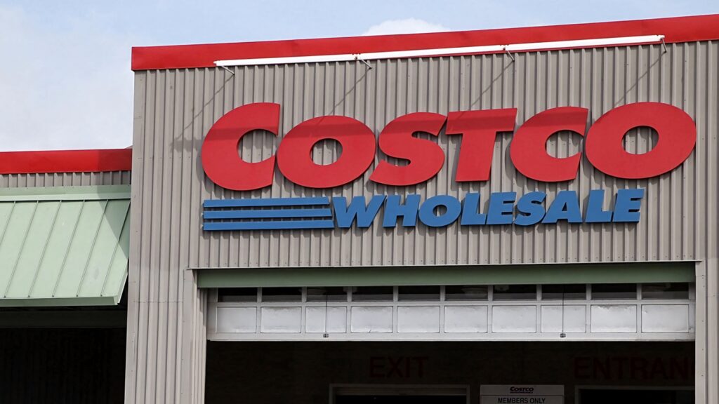Costco Wholesale storefront wallpaper with bold red blue branding on dark gray industrial facade