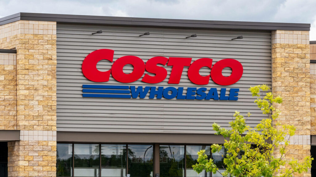 Costco Wholesale red blue sign on modern stone metal exterior with green plants at entrance wallpaper
