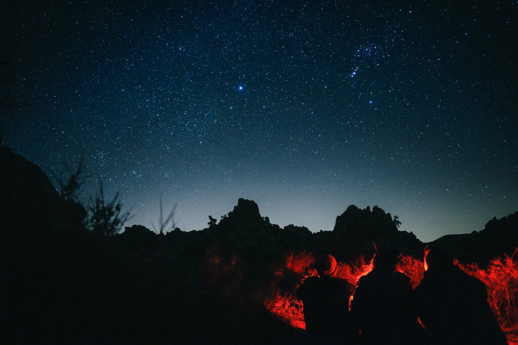 Nighttime Serenity: HD Wallpaper Featuring People Gathered Around a Cozy Campfire