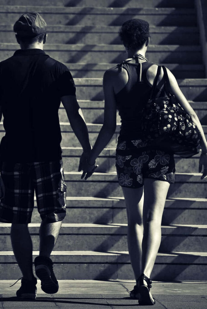 Couple Hand in Hand: Relationship Goals on Stairs of Togetherness Wallpaper