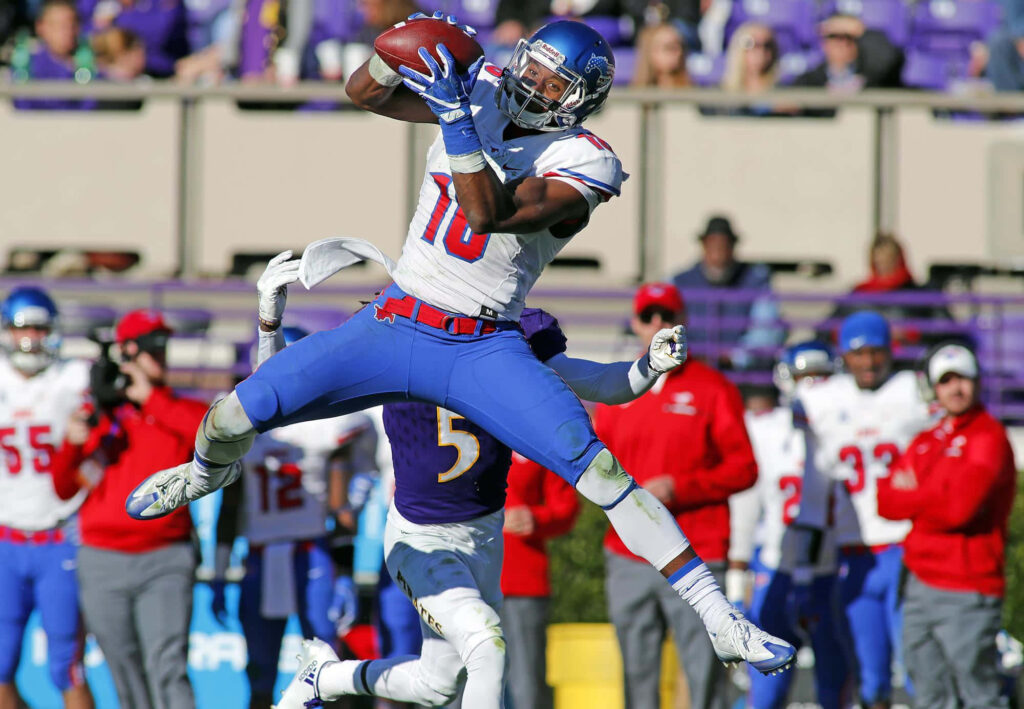 Courtland Sutton leaps mid-air for an impressive catch in vibrant football game action background Wallpaper