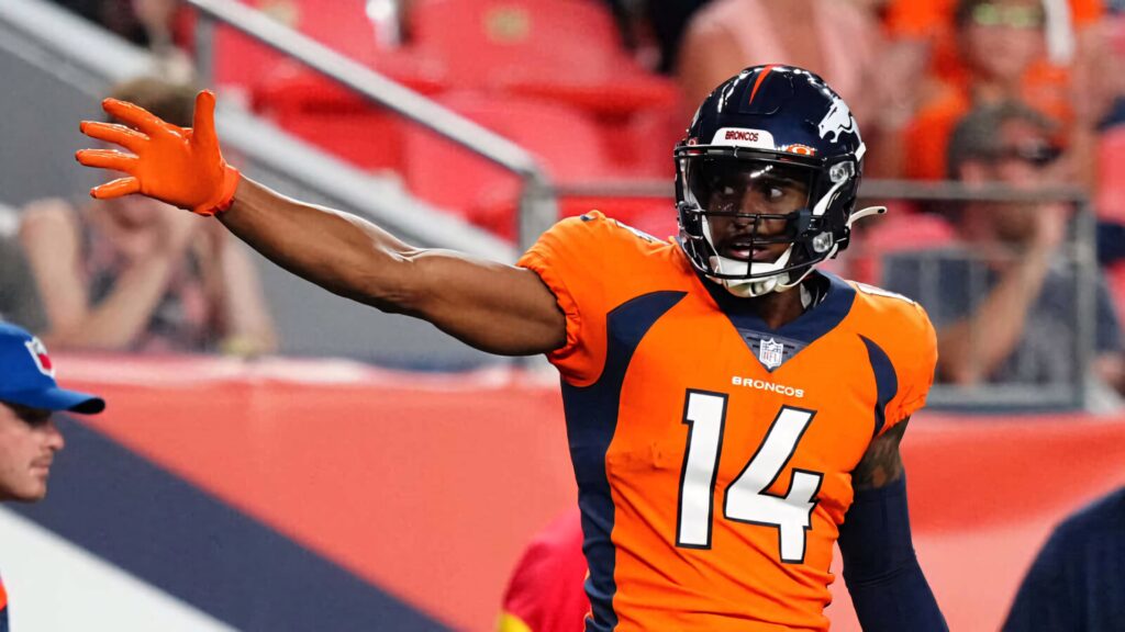 Courtland Sutton Denver Broncos in orange navy uniform reaching out during intense football game action Wallpaper