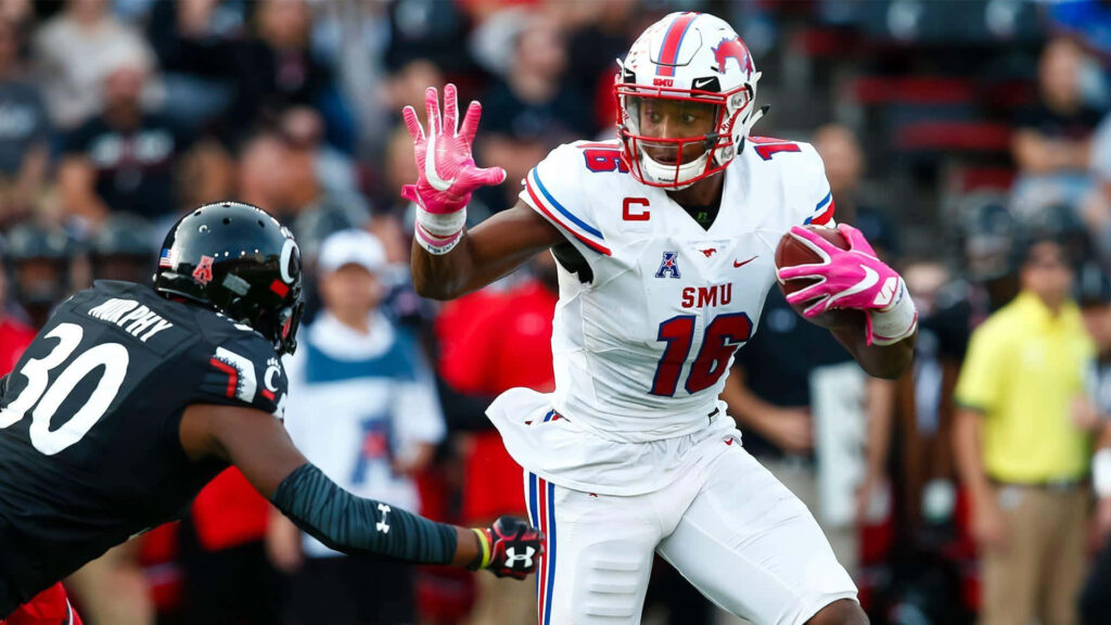 Courtland Sutton in red and white SMU uniform evades defender showing athleticism in game action Wallpaper
