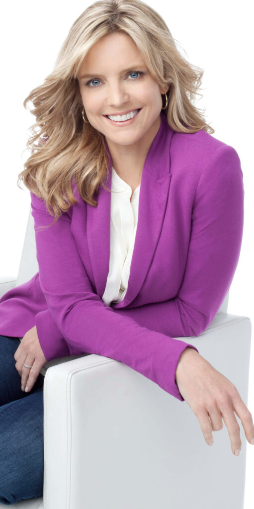 Courtney Thorne-Smith in purple blazer and denim smiling seated against white background wallpaper