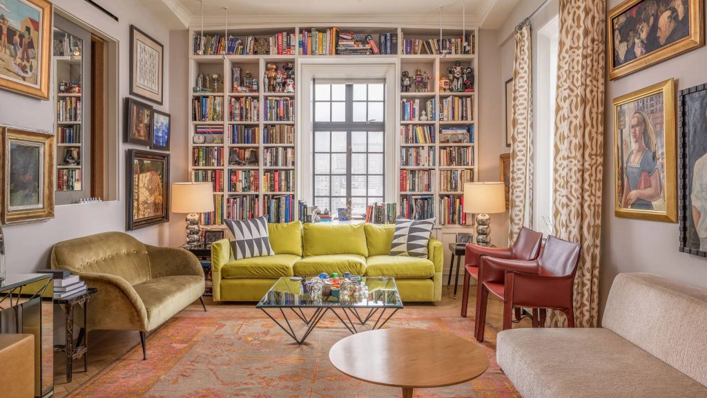 4K living room wallpaper with floor-to-ceiling library chartreuse sofa eclectic art warm lighting