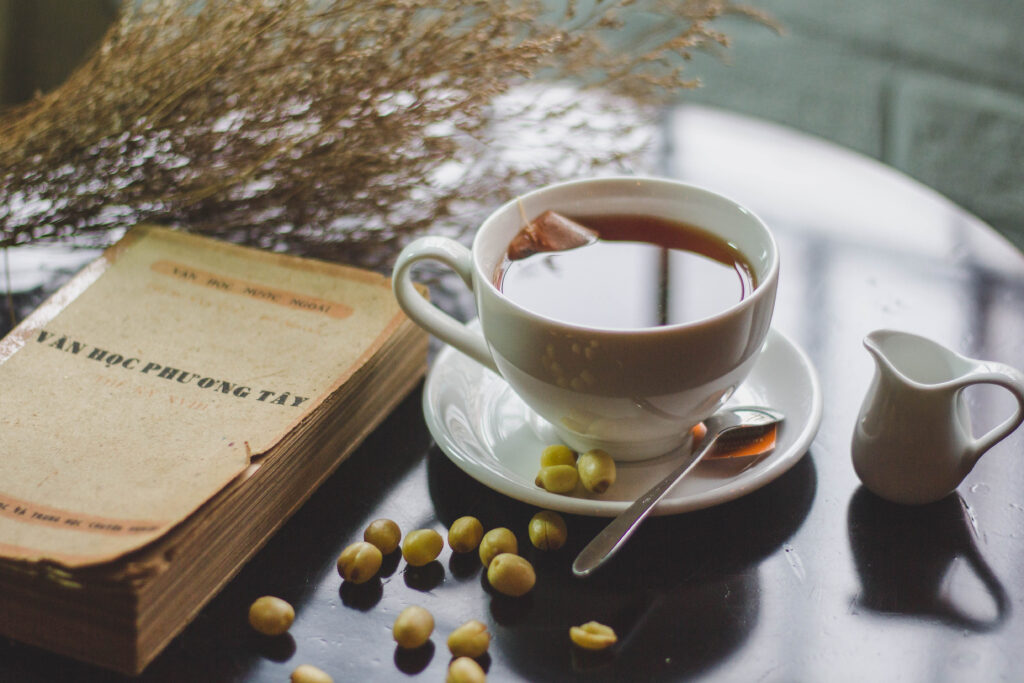 Cozy Tea Scene: Elegant Cup, Rustic Setup & Soft Lighting Wallpaper