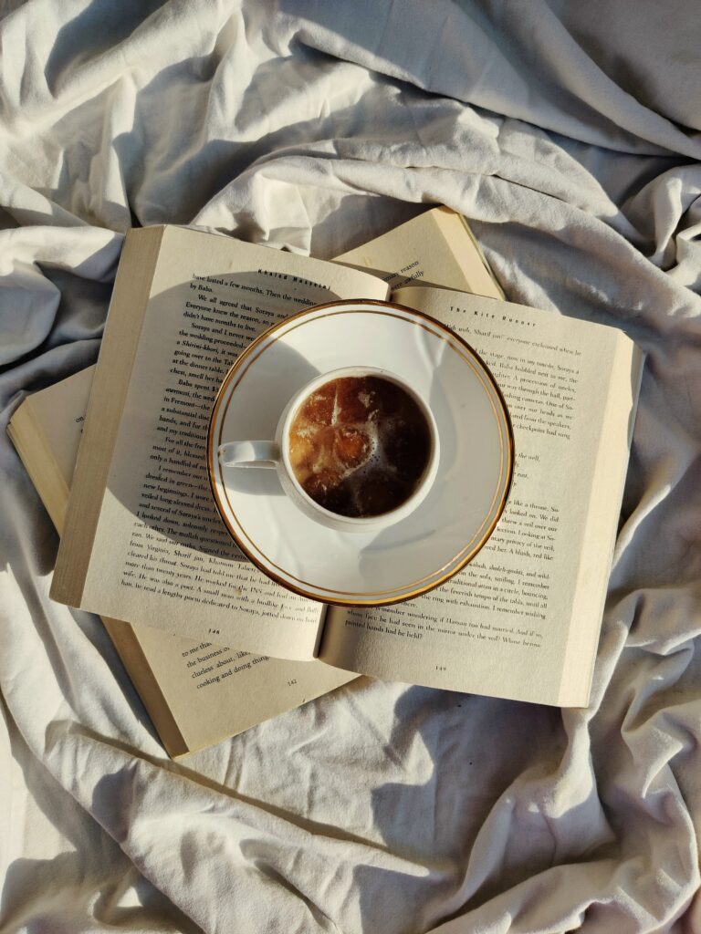 Cozy Wallpaper: Tea Cup on Open Book Amid Soft Crumpled Fabric