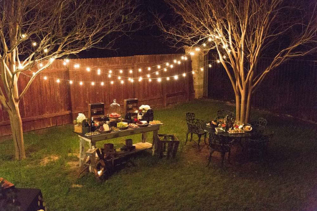Cozy Backyard Night Setup with String Lights & Rustic Dining Vibe Wallpaper