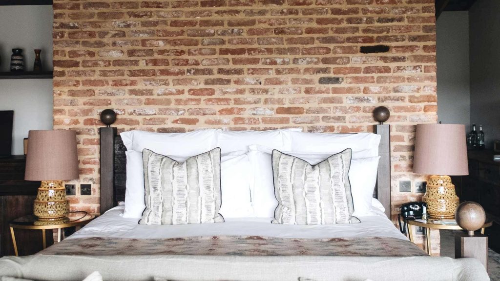 Cozy bedroom virtual background with exposed brick wall white bedding and textured lamps for Zoom Wallpaper