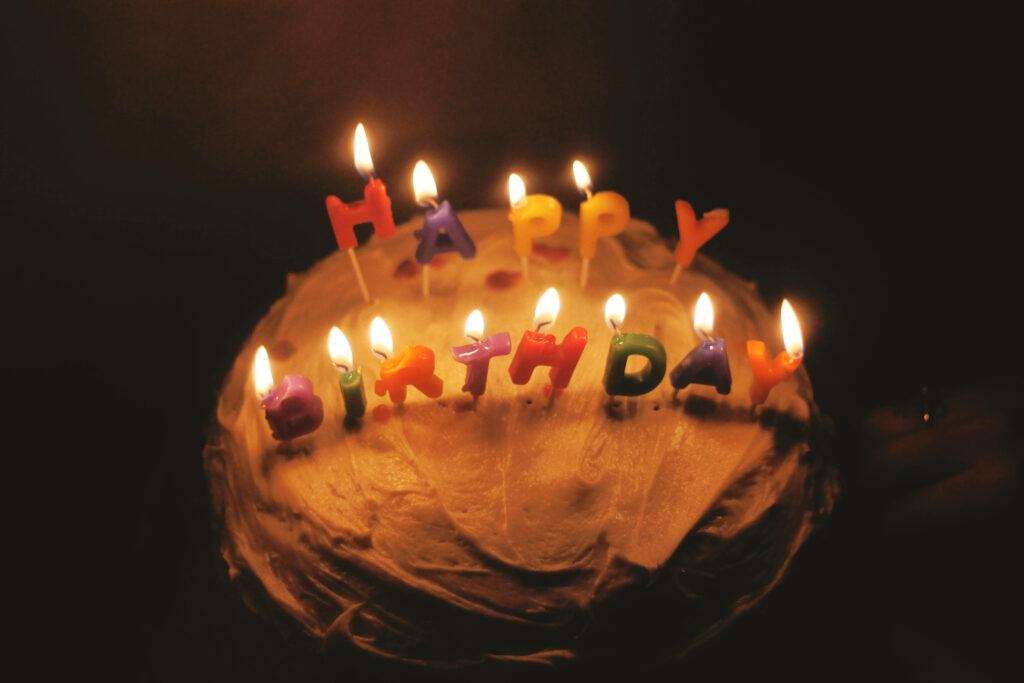 Cozy Birthday Cake with Colorful Candles on Dark Background Wallpaper