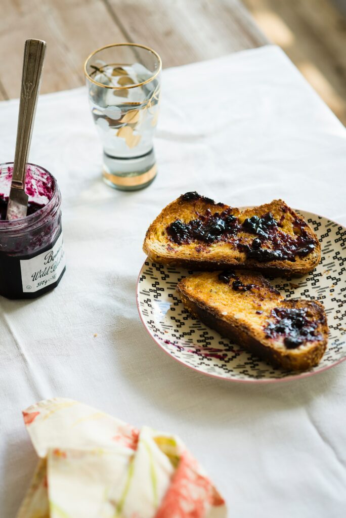 Cozy Breakfast: Toast with Dark Berry Jam on Patterned Plate Wallpaper