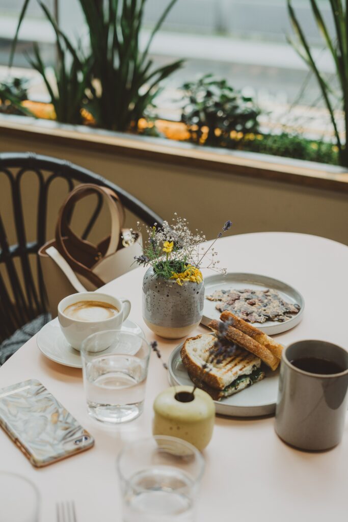 Cozy Breakfast Setup: Coffee, Toasts, and Flowers on a Neat Table Wallpaper