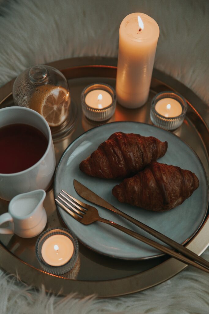Cozy Breakfast Scene: Fresh Croissants, Tea & Lemon Slice Decor Wallpaper