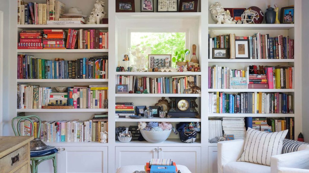 Cozy built-in bookshelf with colorful books and eclectic decor for professional Zoom background Wallpaper