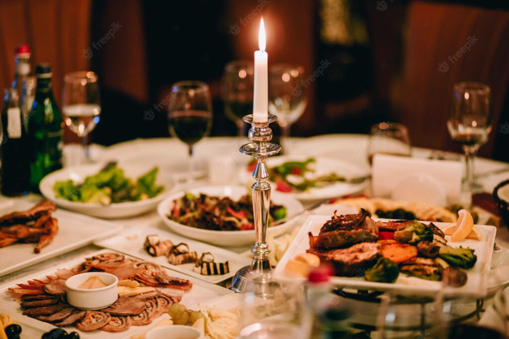 Romantic Candlelit Dinner Setting: Cozy Table with Delicacies & Ambiance Wallpaper