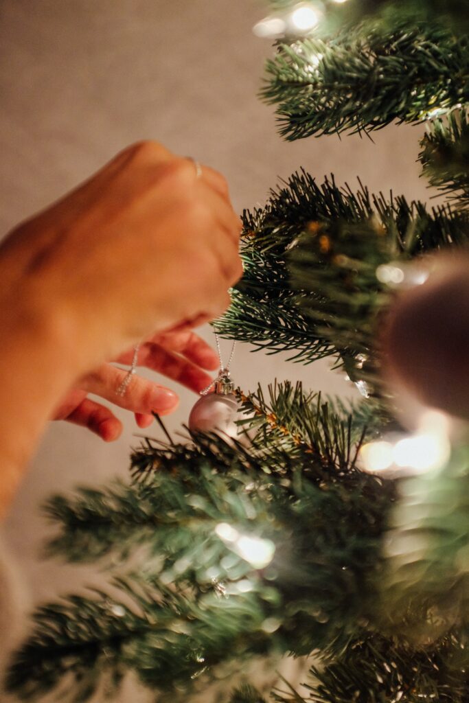 Cozy Christmas Tree Decor: Close-Up of Baubles and Warm Lights Wallpaper