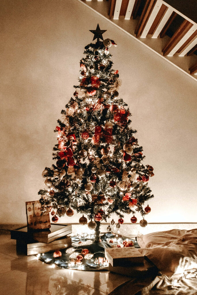Cozy Ambiance: Decorated Christmas Tree with Glowing Lights Wallpaper