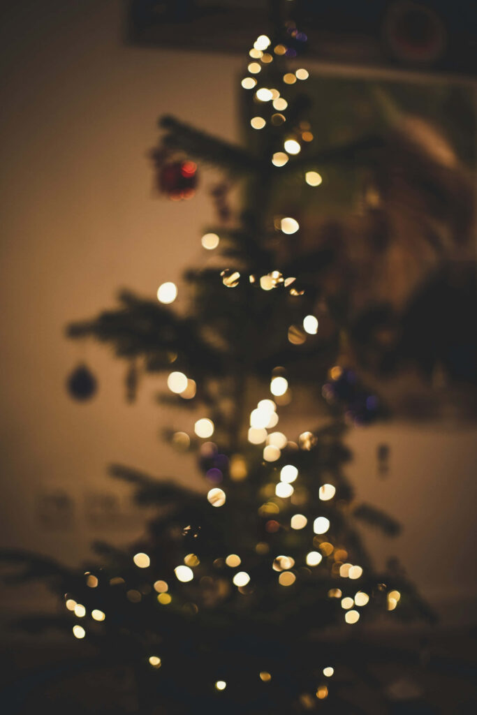Cozy Christmas Tree Wallpaper with Glowing Lights on Dark Background