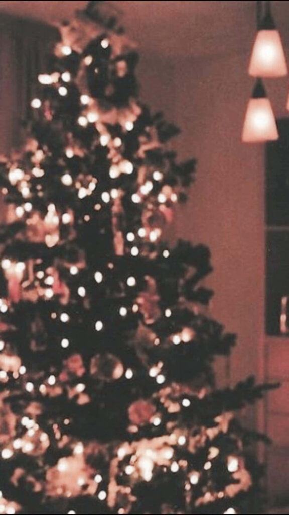 Cozy Christmas Scene with Warmly Lit Decorated Tree Wallpaper